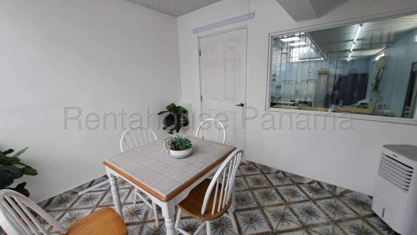 Minimalist dining area or waiting space with white wall and patterned floor in San Francisco Panama