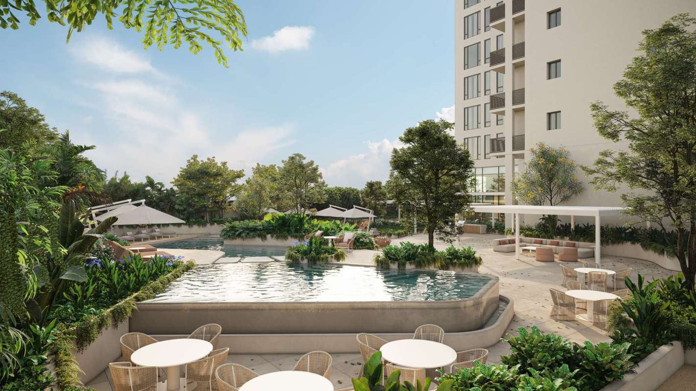 Tropical infinity pool with lush gardens and sun loungers at Blau Residence Panama