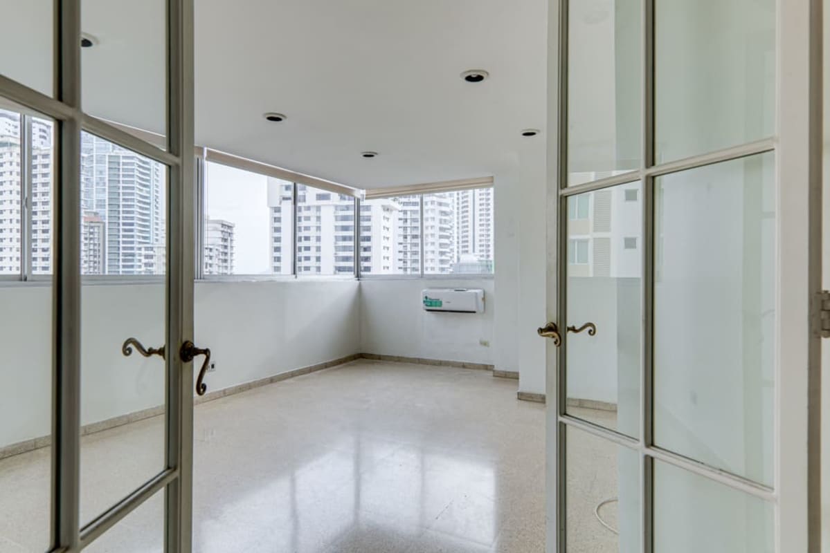 Panoramic enclosed balcony/sunroom with windows overlooking Panama City skyline at PH Marina Plaza Marbella