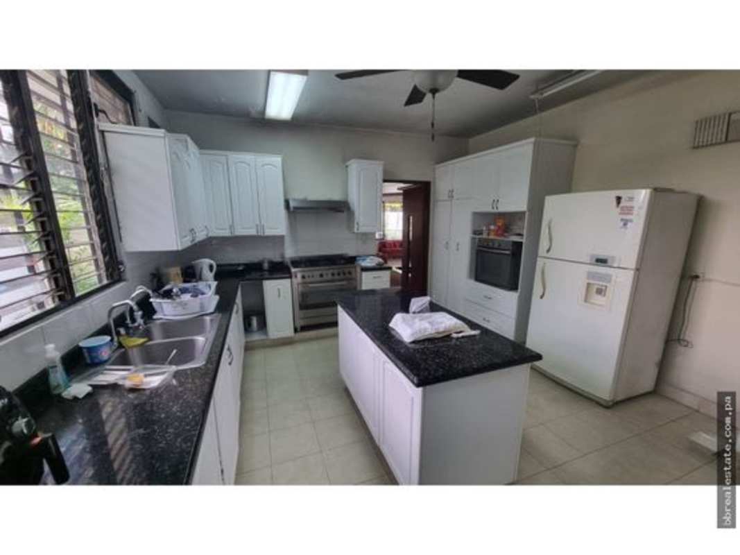 Spacious sunny living area with large windows and garden access in rental house Obarrio