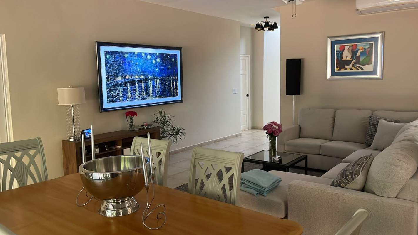 Living room with sectional sofa, glass coffee table, fan and decor at Clayton Village Panama for rent