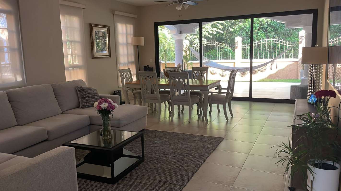 Spacious living room with sectional sofa, dining set, sliding doors to terrace in Clayton Village Panama rental home