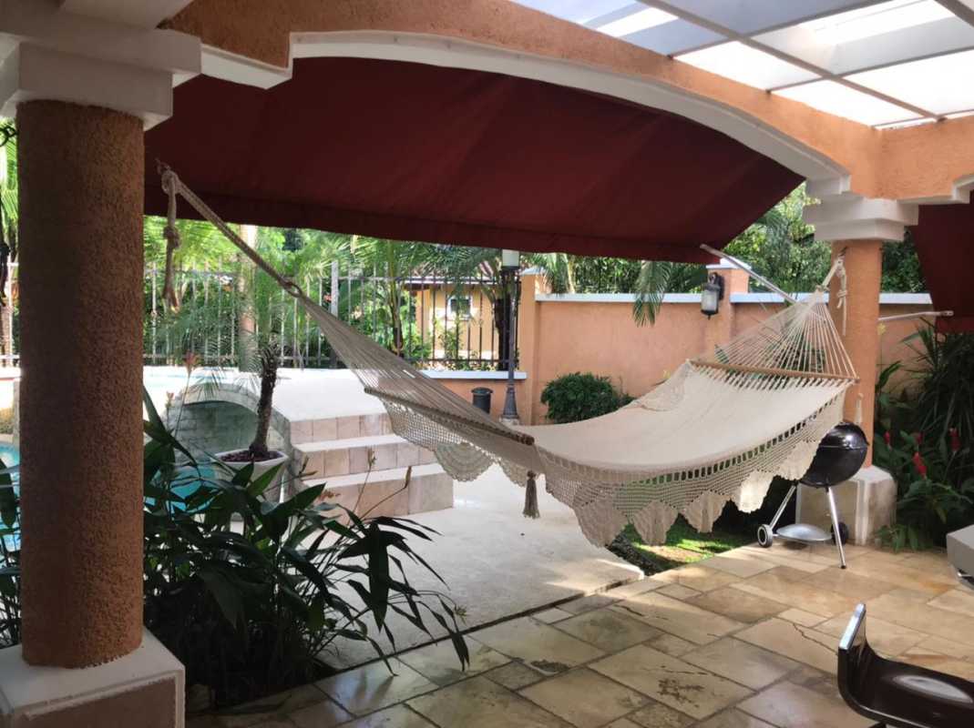 Covered Mediterranean style terrace with hammock, seating, pool and garden at Clayton Village Panama