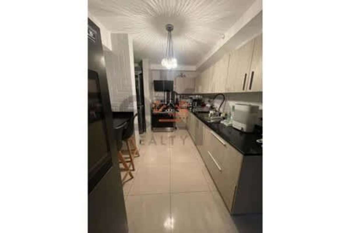 Kitchen with granite countertops, light wood cabinets and breakfast bar in PH Mei Tower Betania Panama
