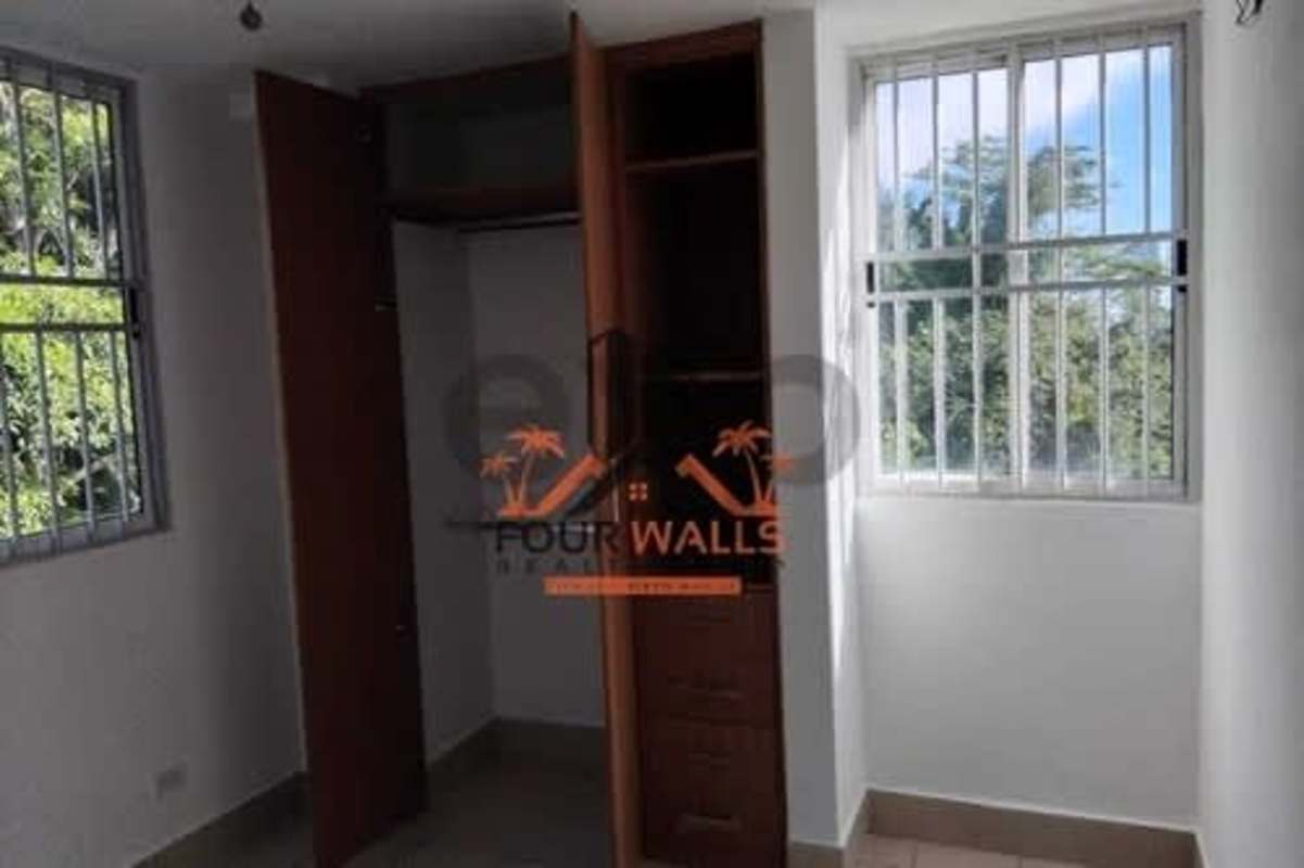 Bedroom featuring built-in wooden closet and two windows PH Met View Betania Panama