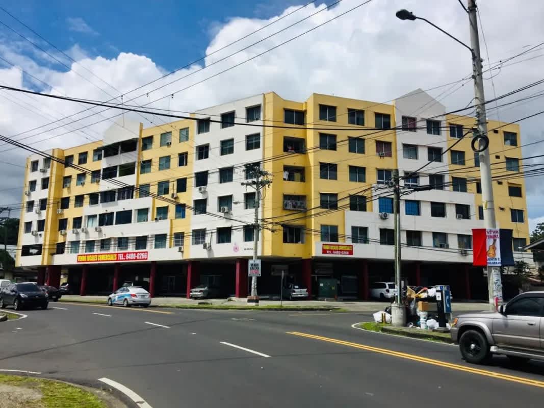 Facade of PH Rio Plaza mixed-use complex with bright yellow paint, retail on ground floor at Panama City