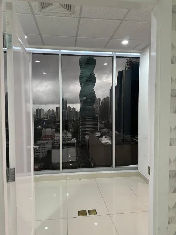 Private office room featuring floor-to-ceiling windows with view of iconic Twist Tower Panama