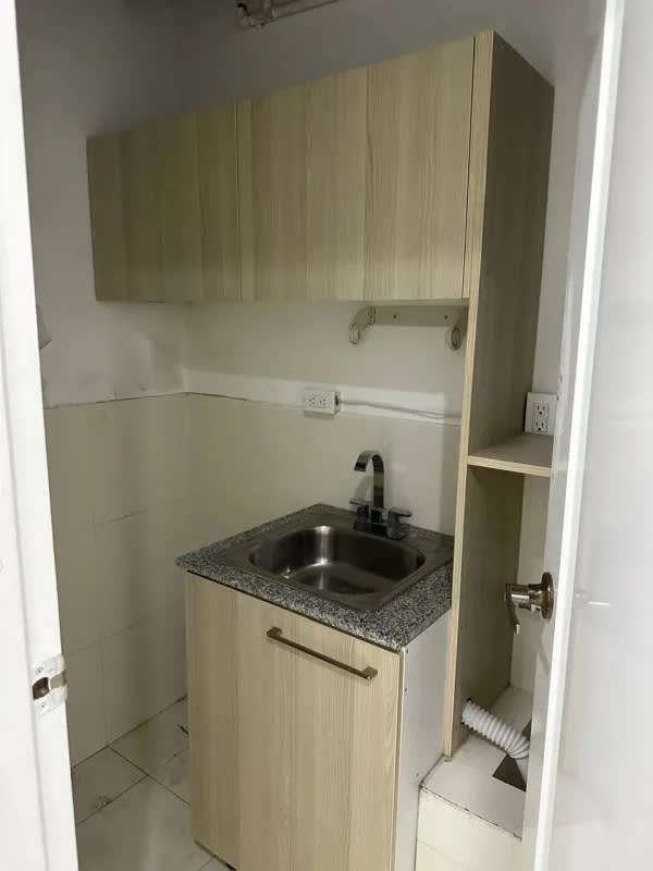Light wood kitchenette with granite countertop in Panama office space Obarrio