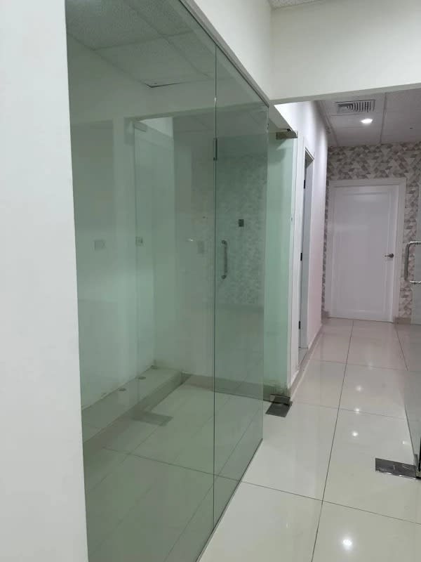 Hallway with glass partitions and tiled floors at Panama Design Center Tower