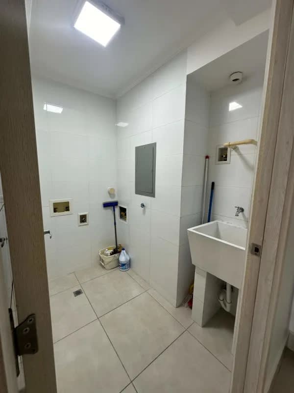 Utility laundry room with sink and tile walls PH Sky Point apartment Panama