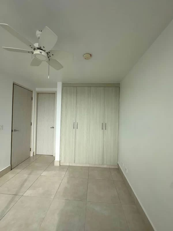 Minimalist bedroom with built-in wardrobe, ceiling fan, tile floor PH Sky Point Panama apartment