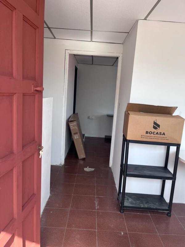 Interior space with tiled floors, red wood door, shelving unit, white walls in Panama rental