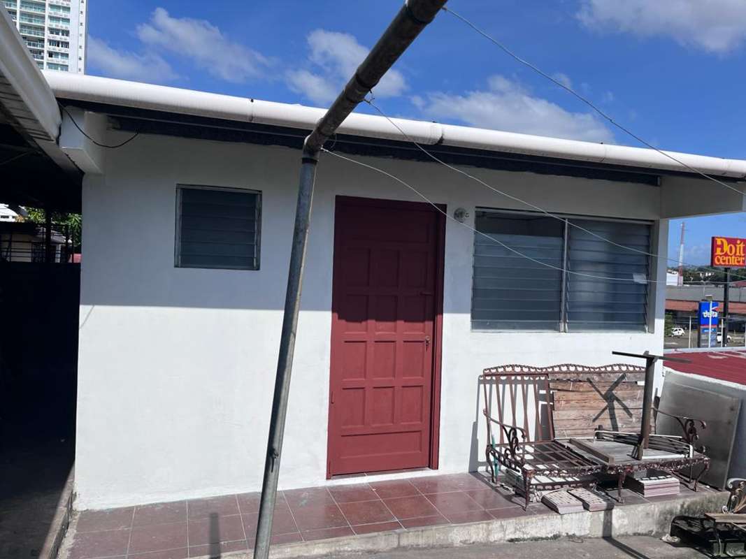 White painted home with red door, louvered windows and porch in Panama rental house
