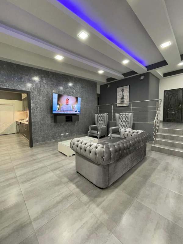 Dining area with coffered LED-lit ceiling, gray furnishings in rental duplex Altos del Panamá