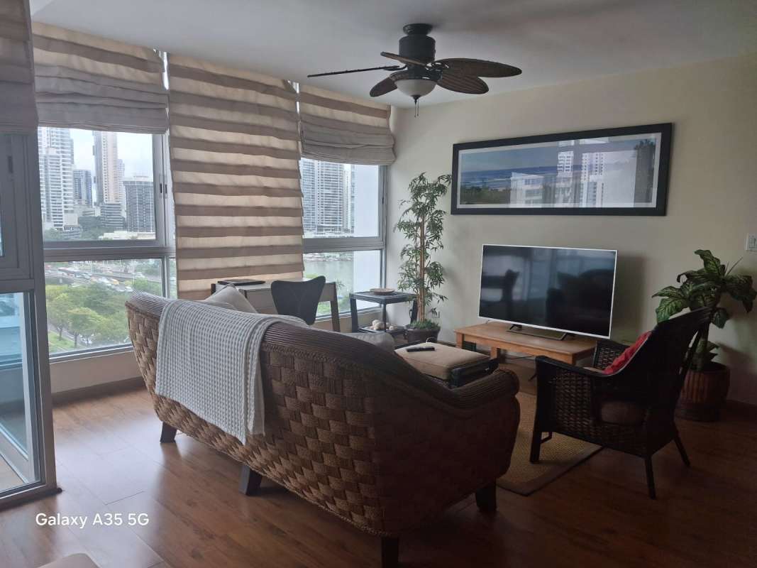 Bright living room with large windows, rattan furniture, city skyline and ocean view in PH Bayfront Tower Avenida Balboa