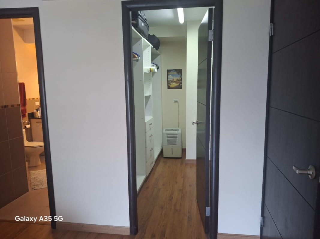 Hallway to walk-in closet and bathroom in PH Bayfront Tower furnished apartment with hardwood floors Panama City