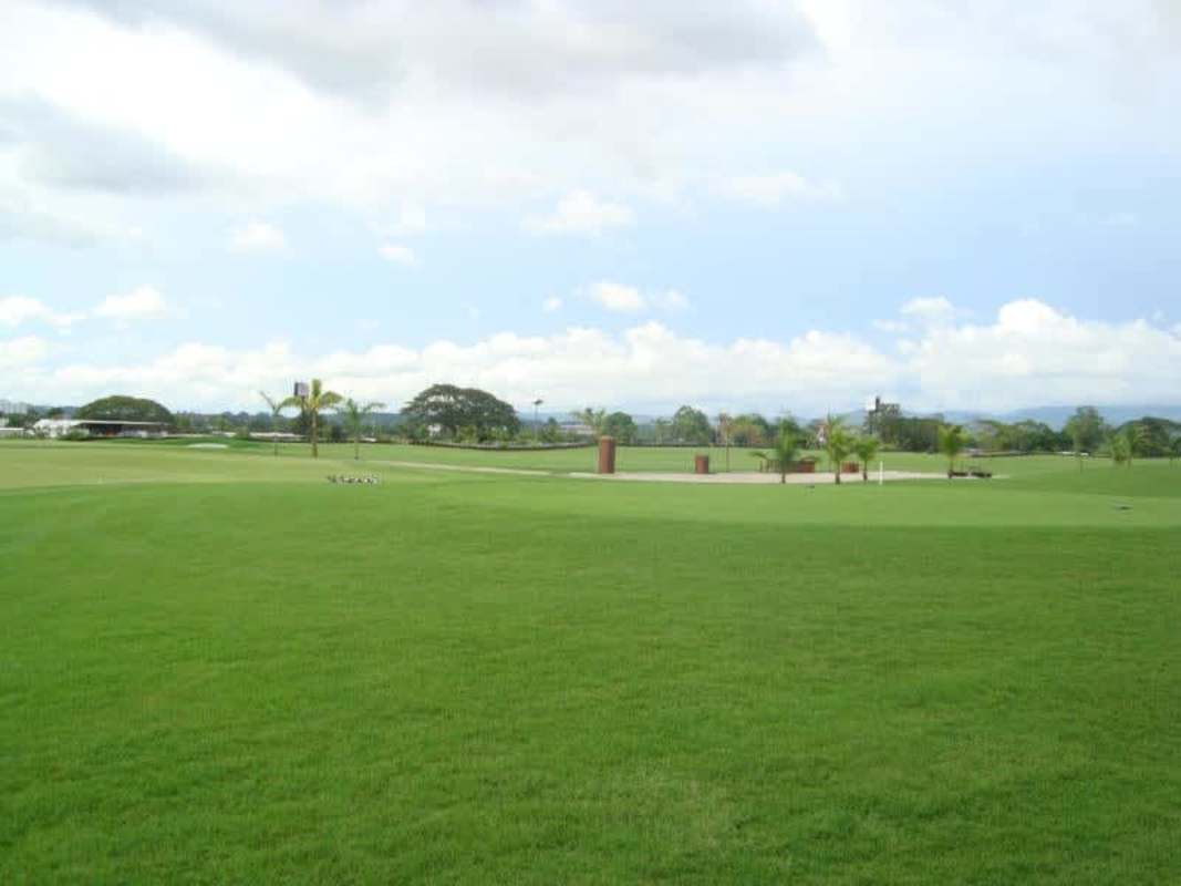 Golf course lot with palm trees and city skyline in distance Santa Maria Country Club Panama