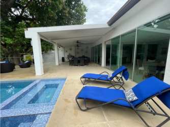 Covered patio with dining area overlooking private pool and gardens at Coral Beach Villas Coronado Panama