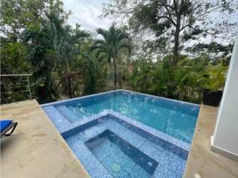 Modern infinity swimming pool surrounded by tropical gardens in Coral Beach Villas Coronado Panama for rent