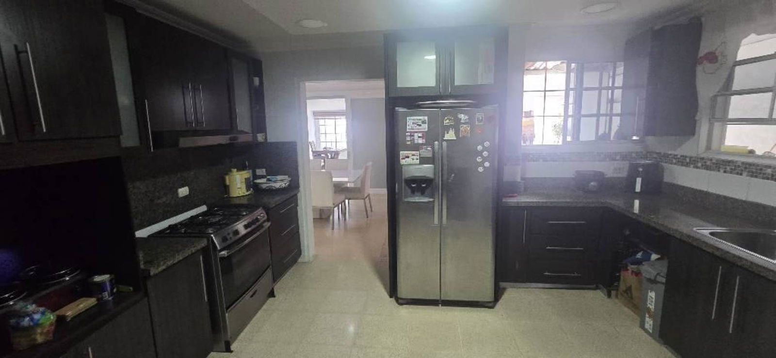 Kitchen with dark wood cabinets and granite countertops in Costa Bella home Panama City