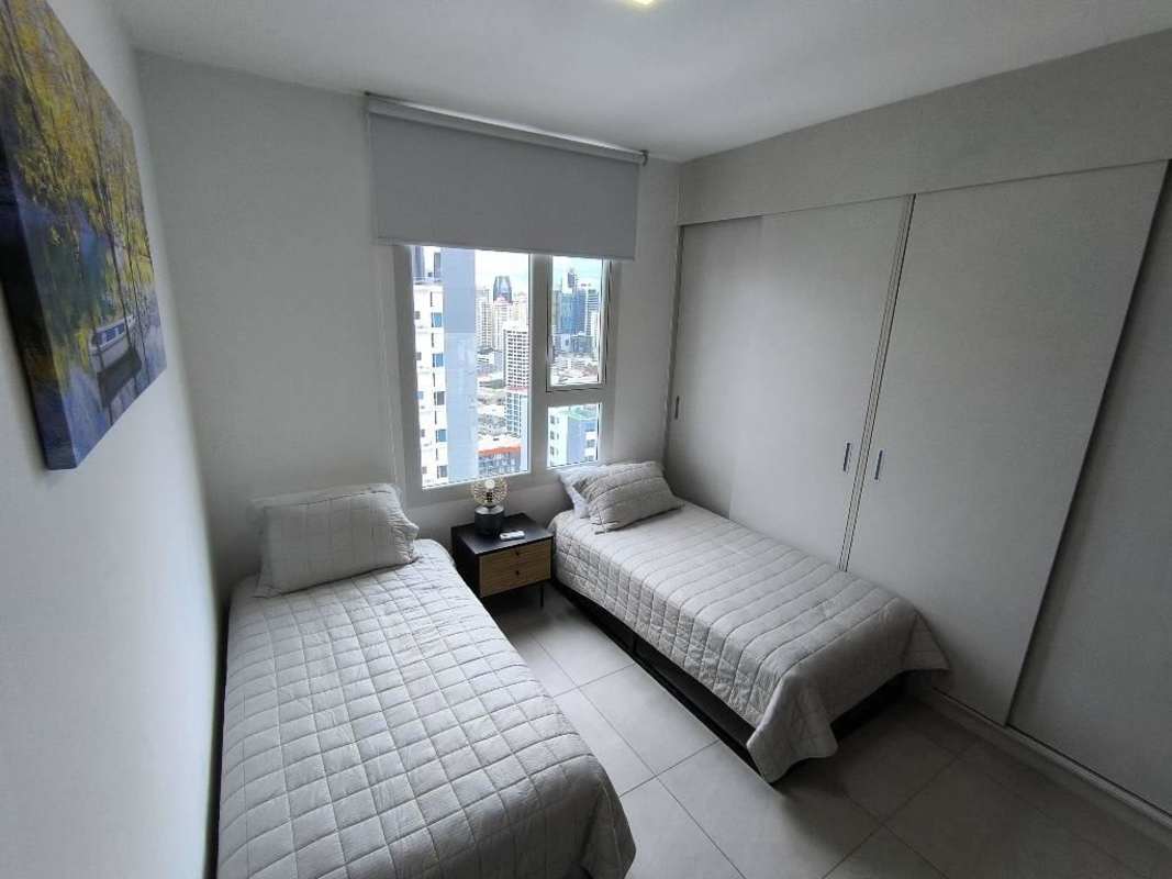 Bedroom with two beds large window skyline view PH Van Gogh El Cangrejo furnished apartment Panama