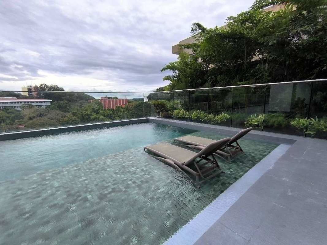 Modern pool deck with loungers rooftop view PH Van Gogh apartment building Panama City