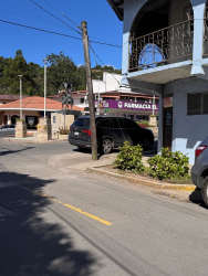 Corner view of pharmacy and commercial buildings with traffic in Bajo Boquete