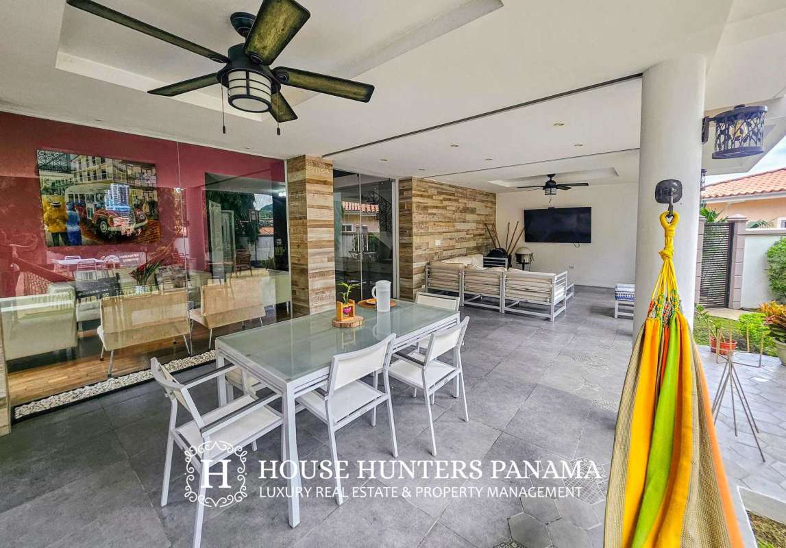 Modern covered patio with dining table, lounge seating, hammock and TV at Colonia Fuente de Fresno house