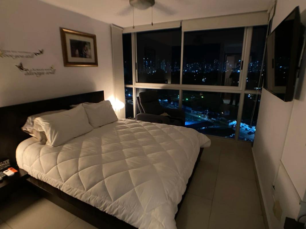 Modern bedroom with large window and minimalist decor in Panama condo Parque Lefevre