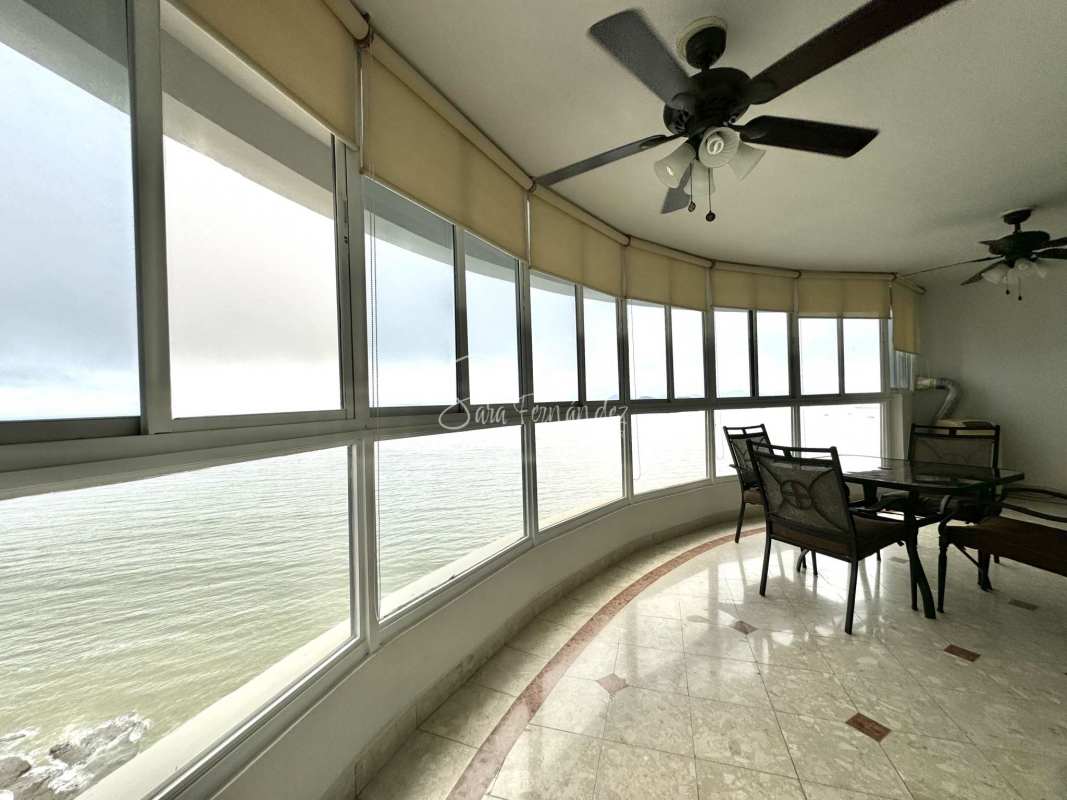 Curved enclosed balcony sunroom with panoramic bay views and ceiling fans Punta Paitilla apartment