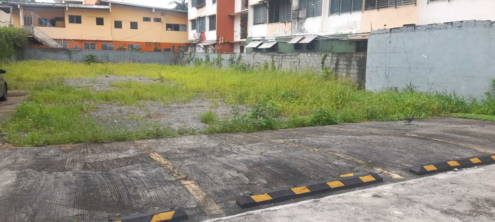 Urban lot with concrete parking area beside apartment buildings on Via Porras Panama City