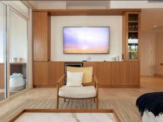 Spacious contemporary living room with mounted TV and wood cabinetry at Marina Village Buenaventura Panama