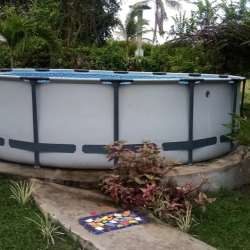 Private above-ground pool surrounded by lush greenery and tropical plants in beach villa Chame Panama rental