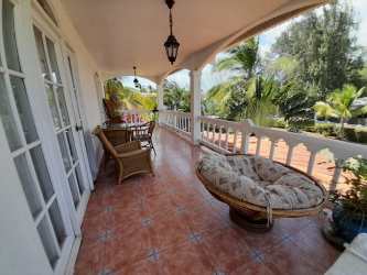 Mediterranean style veranda with wicker furniture, hanging lanterns, and lush tropical garden views in Chame Panama