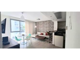 Bright furnished living room and dining space with large window at PH Mosaic Panama City