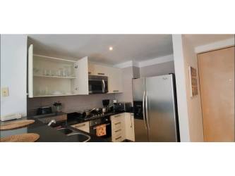 Modern furnished bedroom with balcony access, TV, closet at PH Mosaic Panama Pacifico