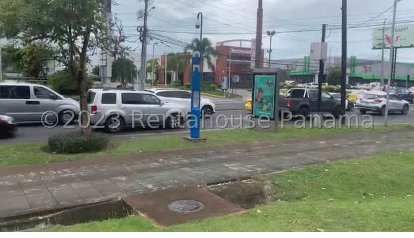 Urban street with storefronts, billboards and vehicular traffic in Los Pueblos Juan Díaz Panama