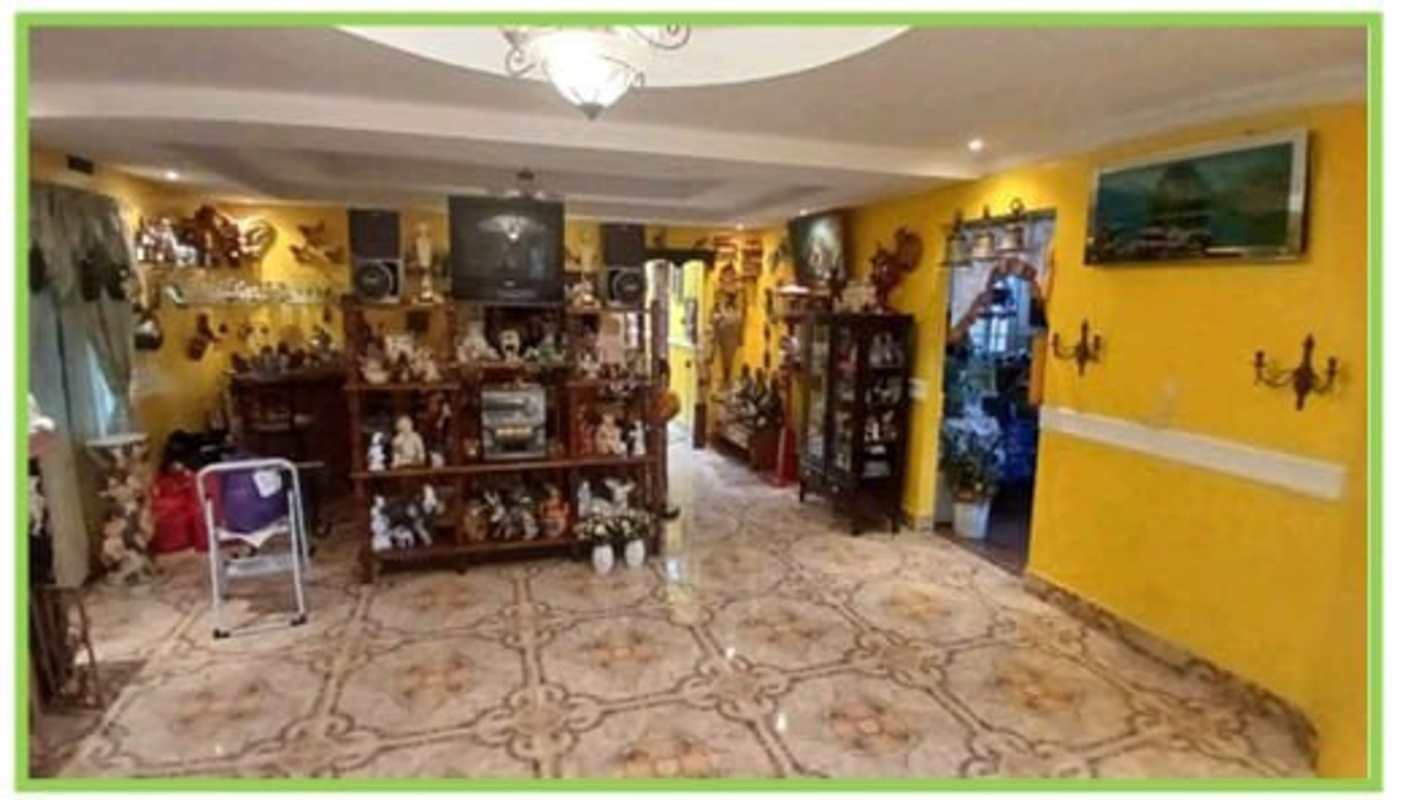 Living room with bright yellow walls, decor, and tiled floors in Juan Díaz Panama house for sale