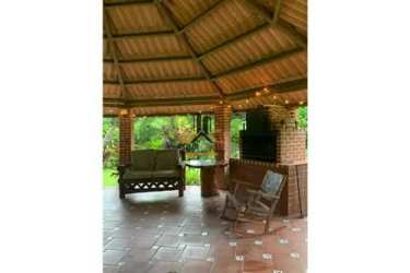 Thatched roof rustic gazebo with BBQ grill swing and garden view in El Valle de Anton estate Panama