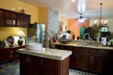 Gated property entrance with palm trees and stucco wall at Playa Coronado beach house