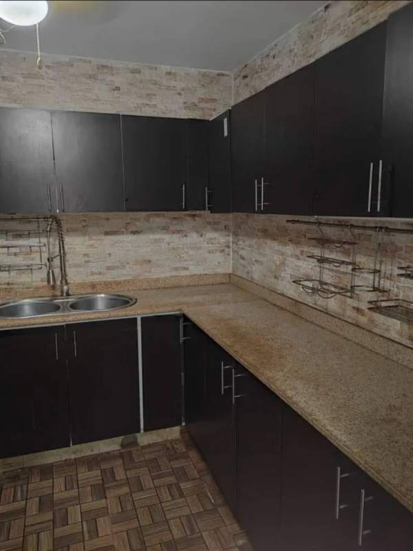 Kitchen with dark cabinets, L-shaped counters, double sink in Cerro Viento Panama