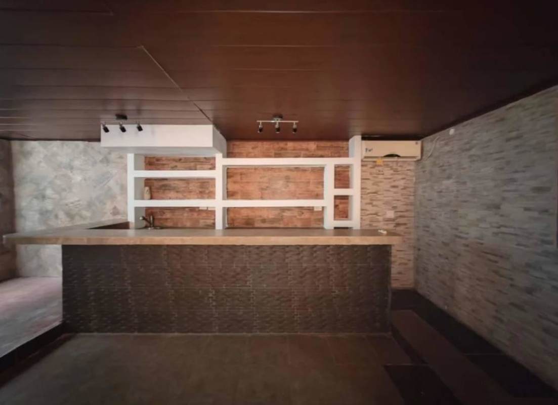 Living room with wood ceiling, built-in shelving, stone accent wall Cerro Viento Panama