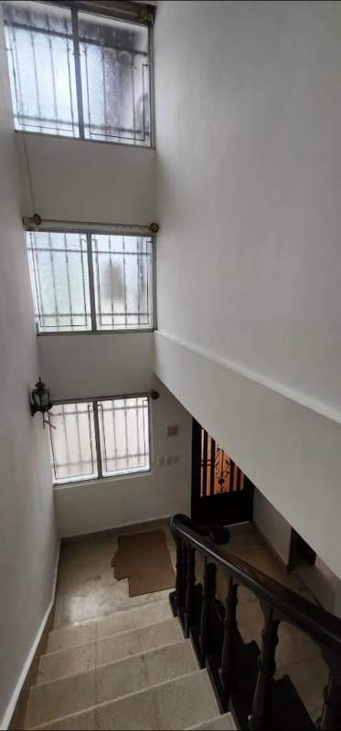 Bright staircase area with wooden railing, windows, lantern light fixture in rental house Altos del Chase Panama City