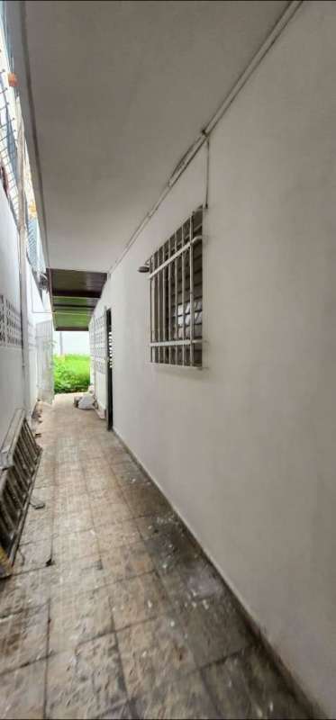 Outdoor corridor with tiled floor, barred windows, partial garden area of rental house in Altos del Chase Panama