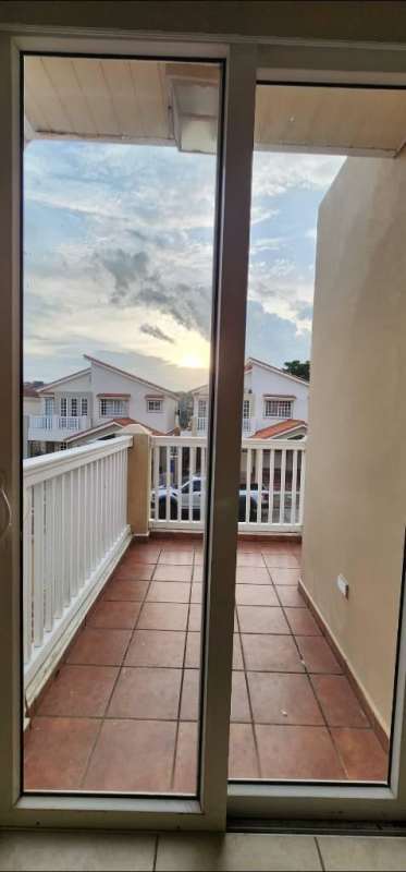 Living space with sliding glass doors and balcony overlooking neighborhood in PH Brisas Heights Panama
