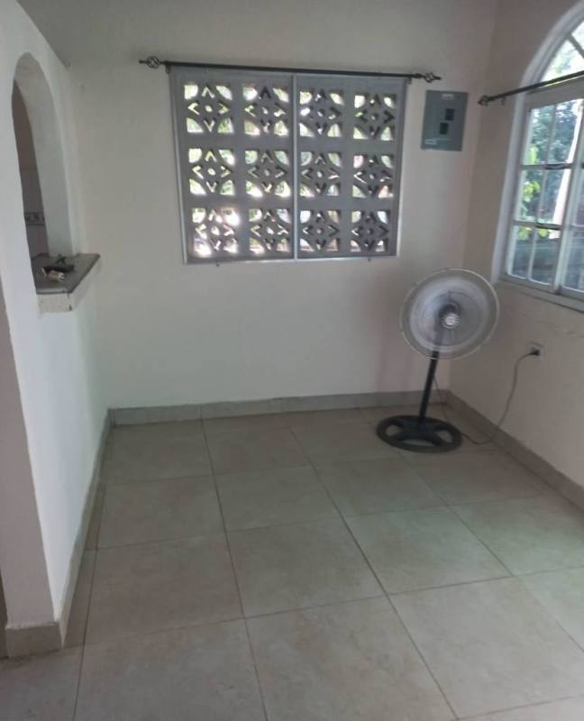 Compact living area with ceramic tile flooring, vent block window at Nuevo Tocumen Panama