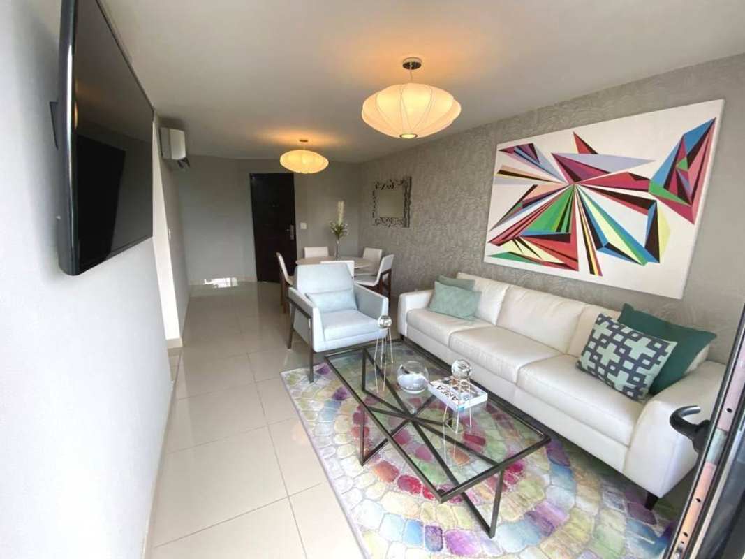 Modern gym with equipment, red accent wall, large windows PH Condado Country Club Panama City