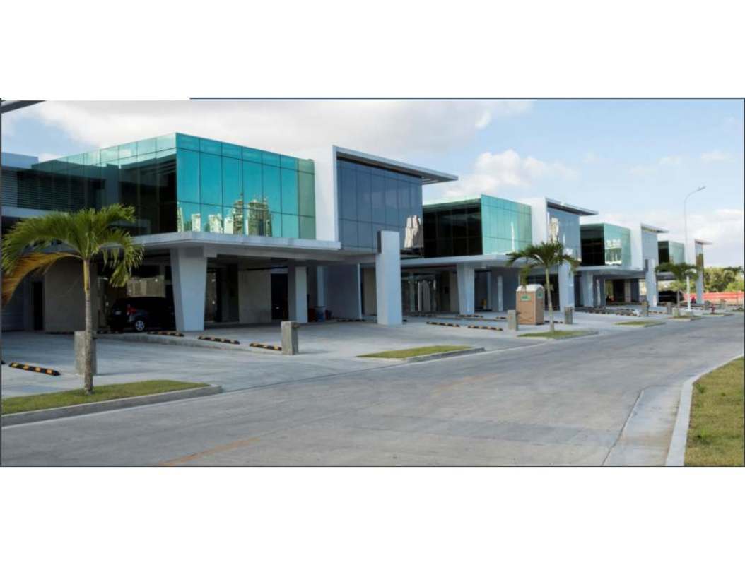 Glass facade commercial buildings with palm trees and parking at Panama Viejo Business Center