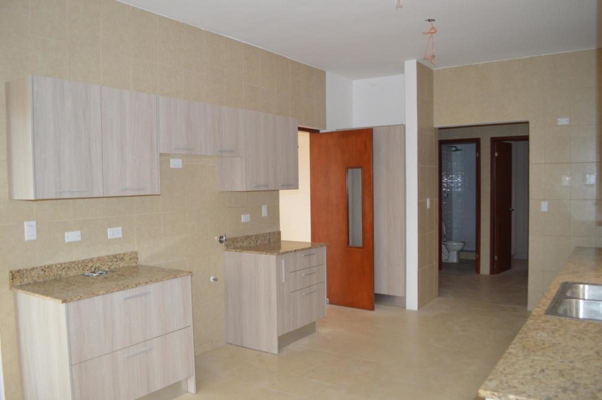 Fenced backyard with green garden and terrace in El Doral Costa Sur house for sale