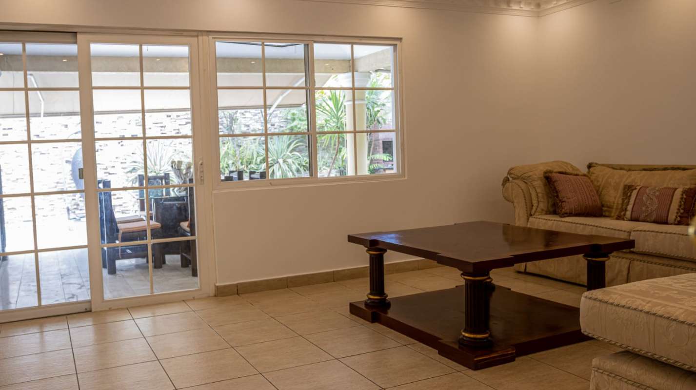 Spacious living area with sliding doors, garden access, tiled floors in Costa del Este home